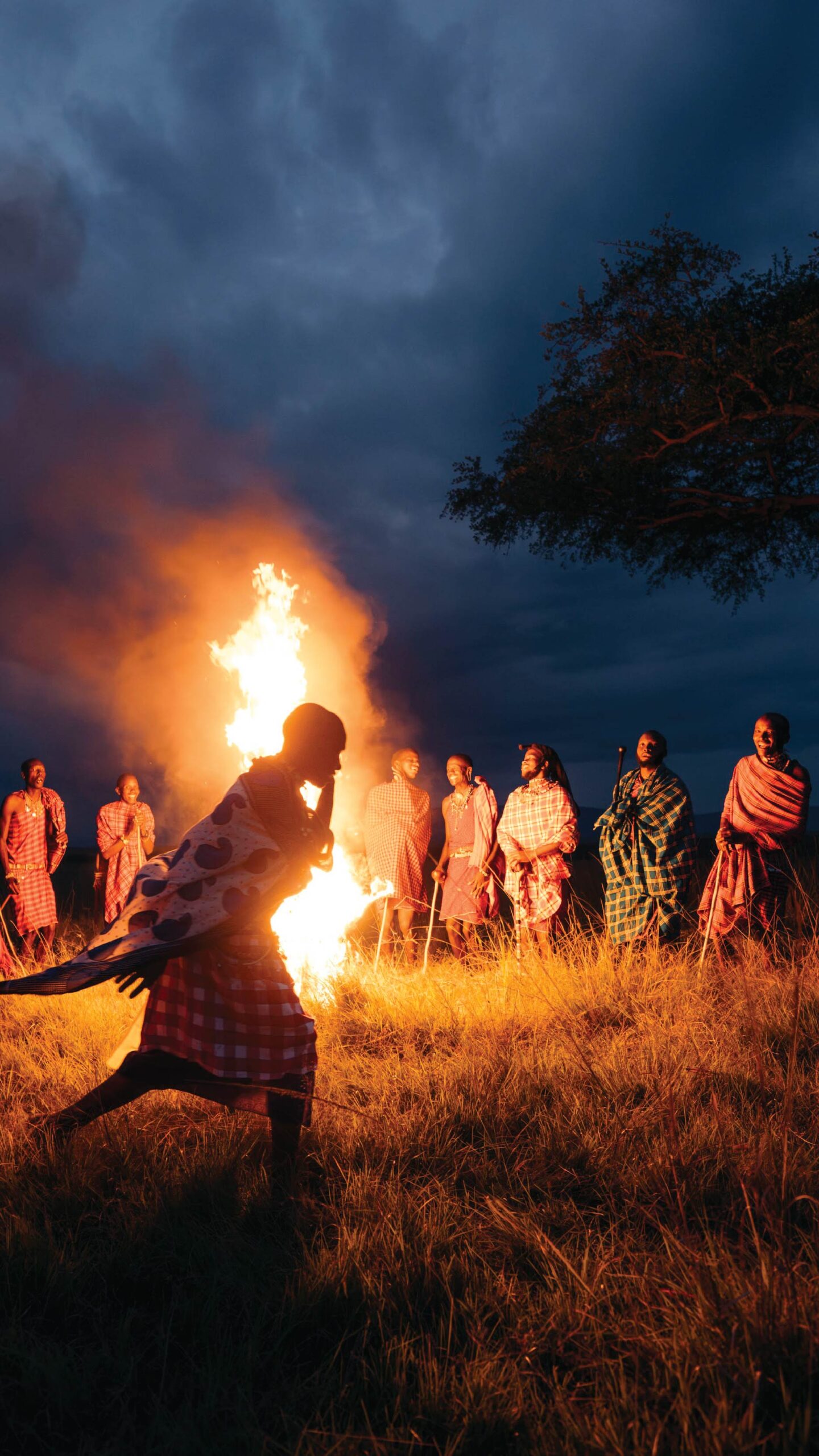 Maasai people gathered around a large campfire during a safari evening in Kenya.