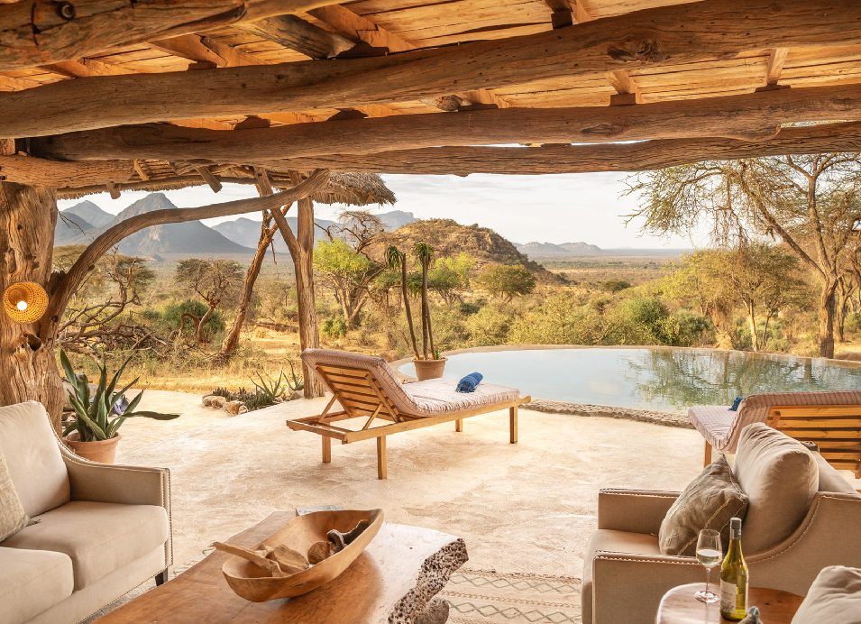 Luxury safari lodge overlooking a natural pool and scenic Kenyan landscape, with comfortable outdoor seating and a shaded wooden veranda.