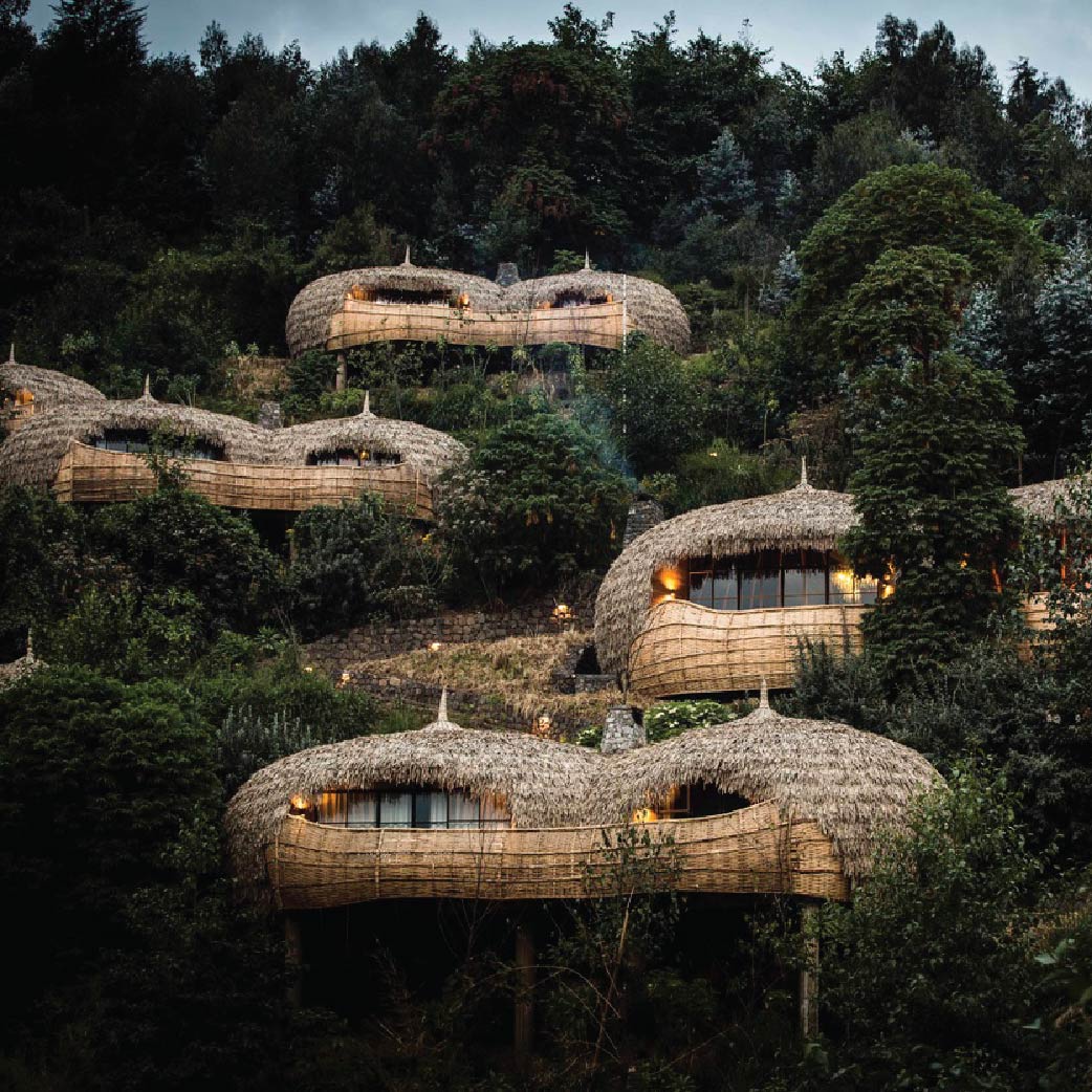 Luxury eco-lodges nestled among lush green trees in Rwanda, featuring curved woven structures and warm evening lighting.