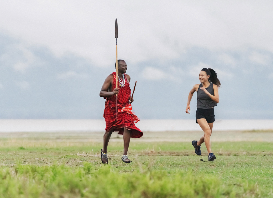 Maasai man and woman running across the grasslands of Tanzania.