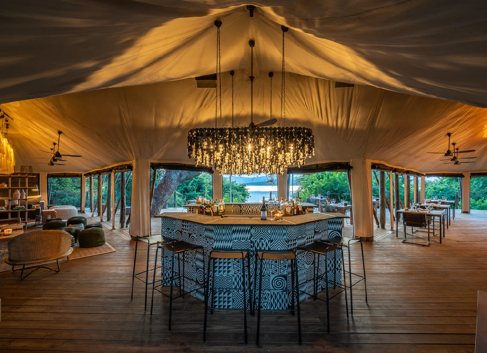 Luxury safari lodge dining and lounge area inside a spacious canvas tent in Rwanda.